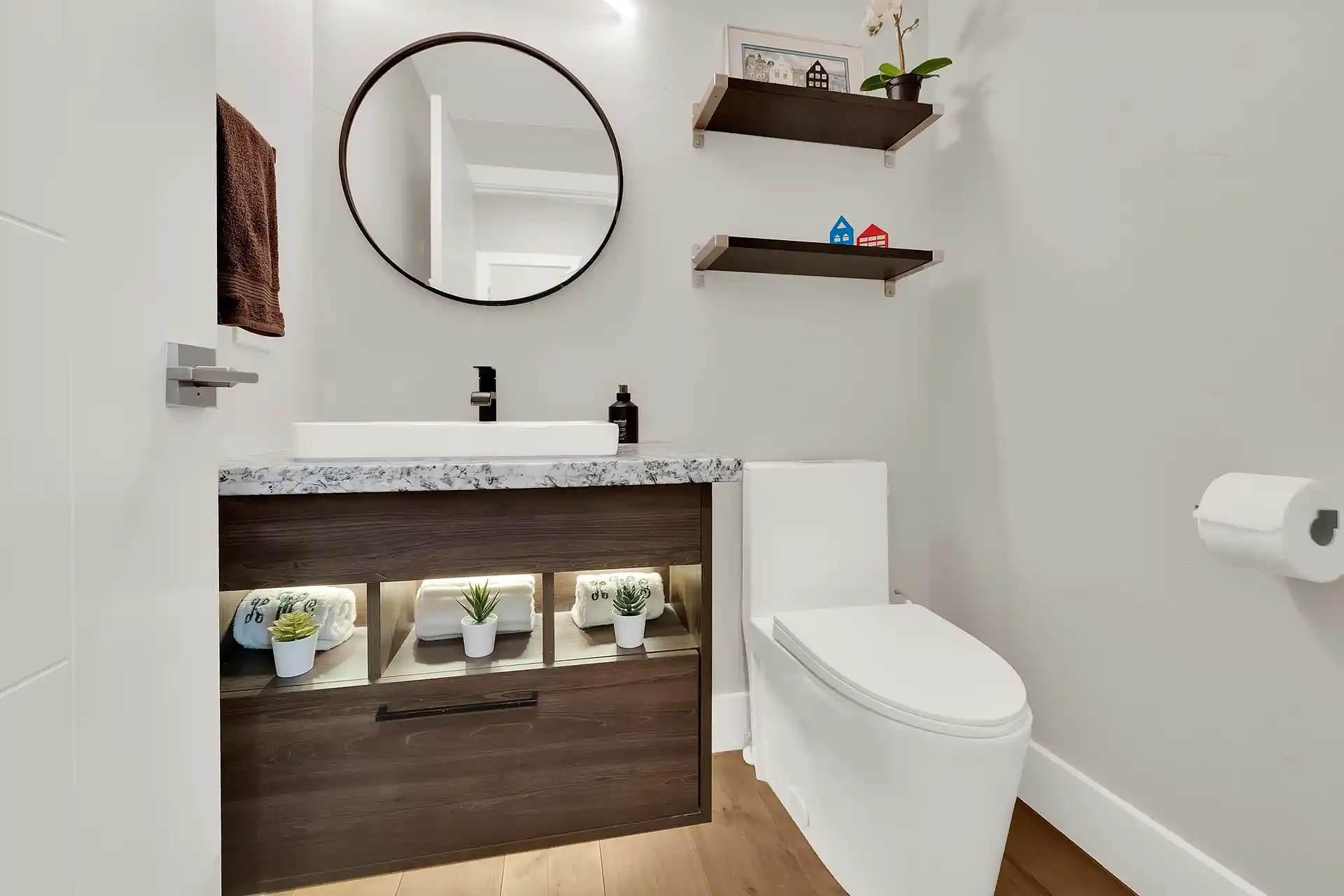 Bathroom with double vanity mirror, custom lighting, and vinyl flooring in Salt Lake City