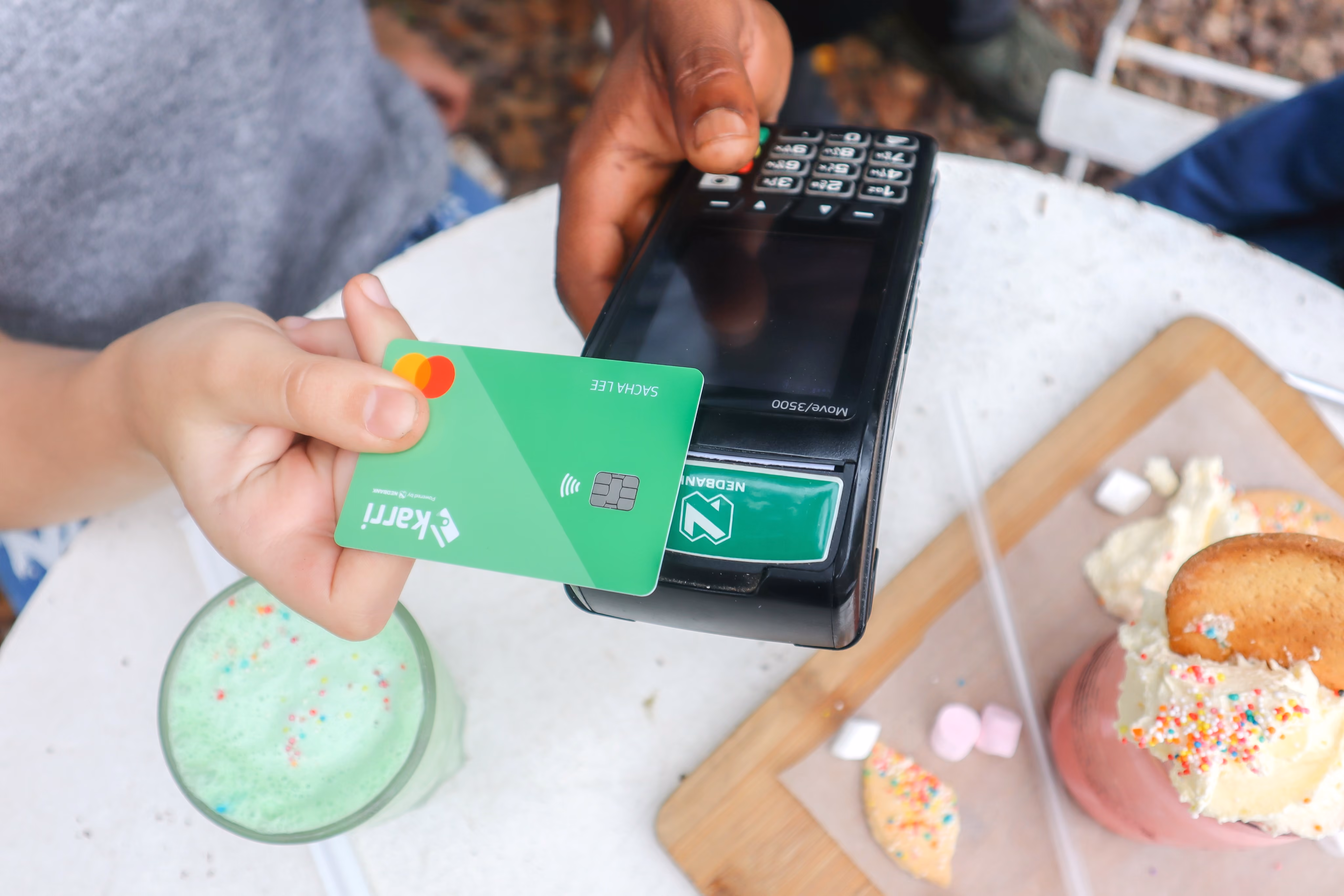 Karri Card Tapping card machine over table of desserts