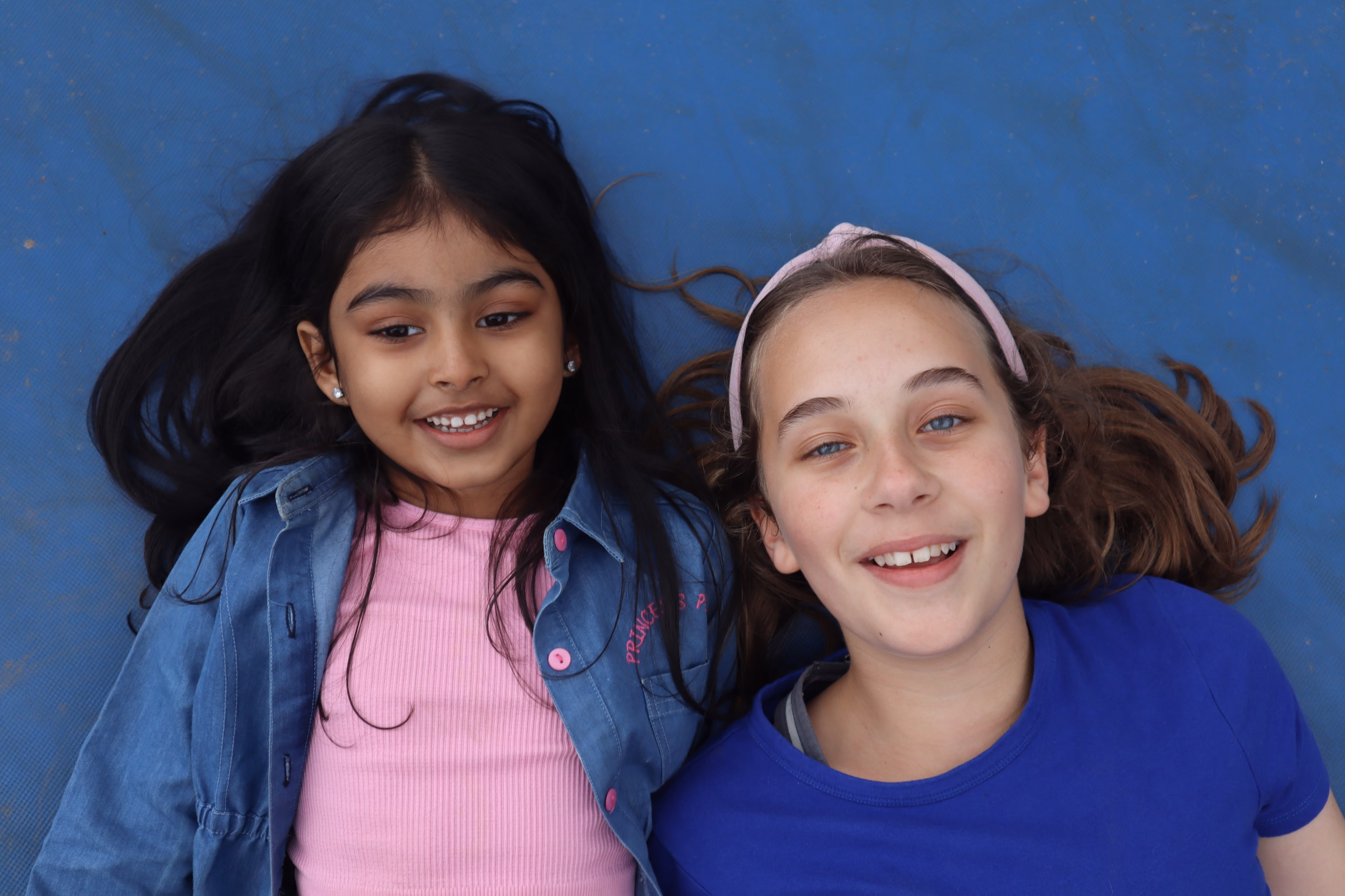 2 Girl lying with on a blue floor