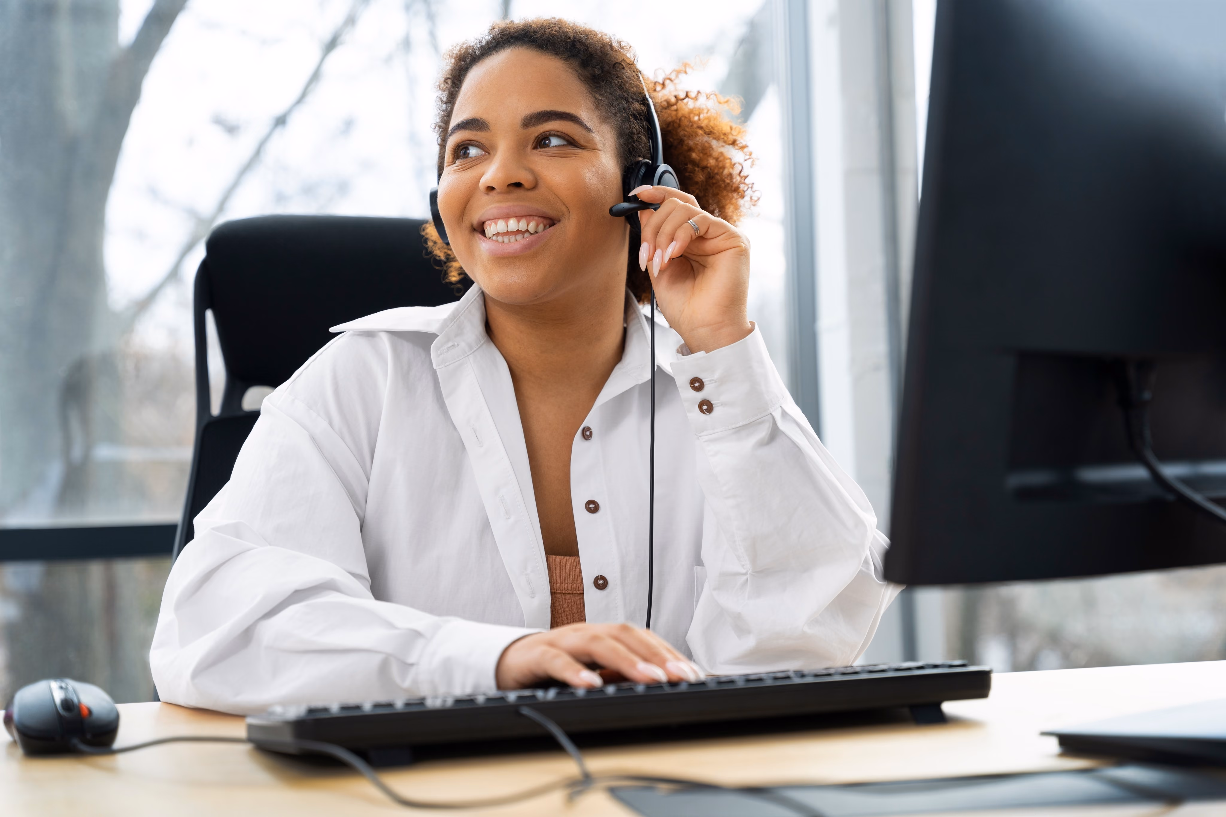 Support Lady sitting at a computer with a headset
