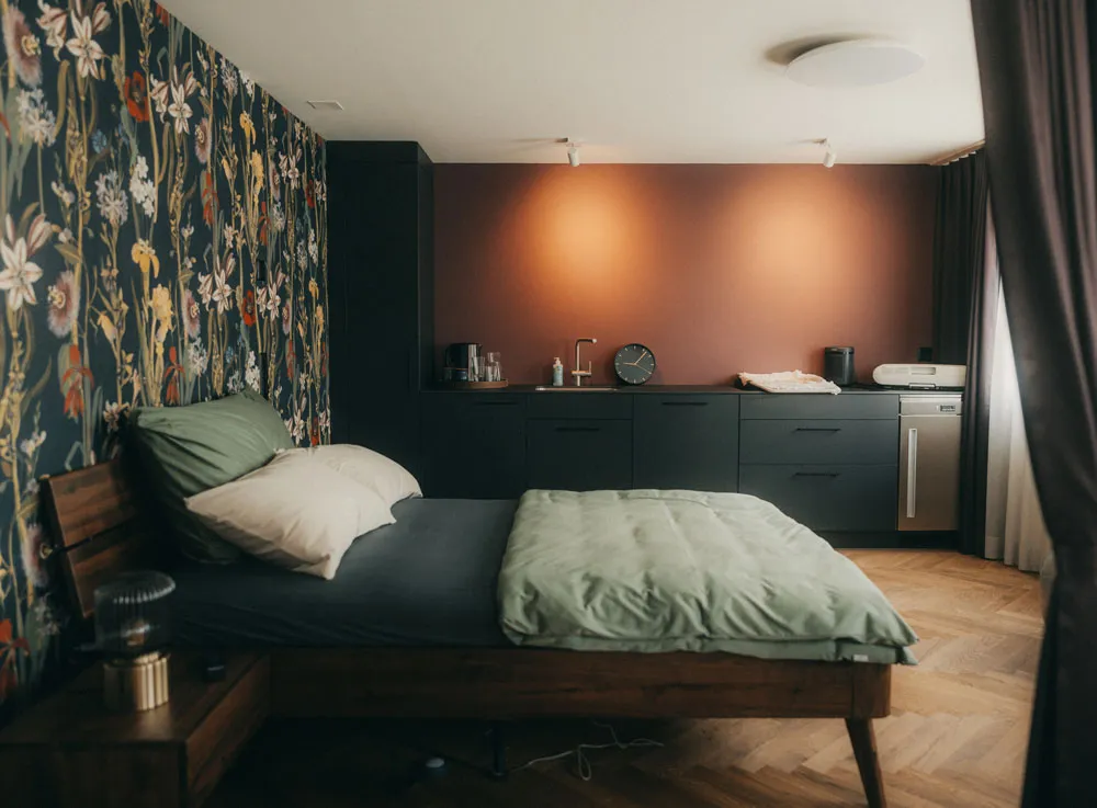 Geburtszimmer mit Bett, Lavabo, Ablageflächen und Blumentapete