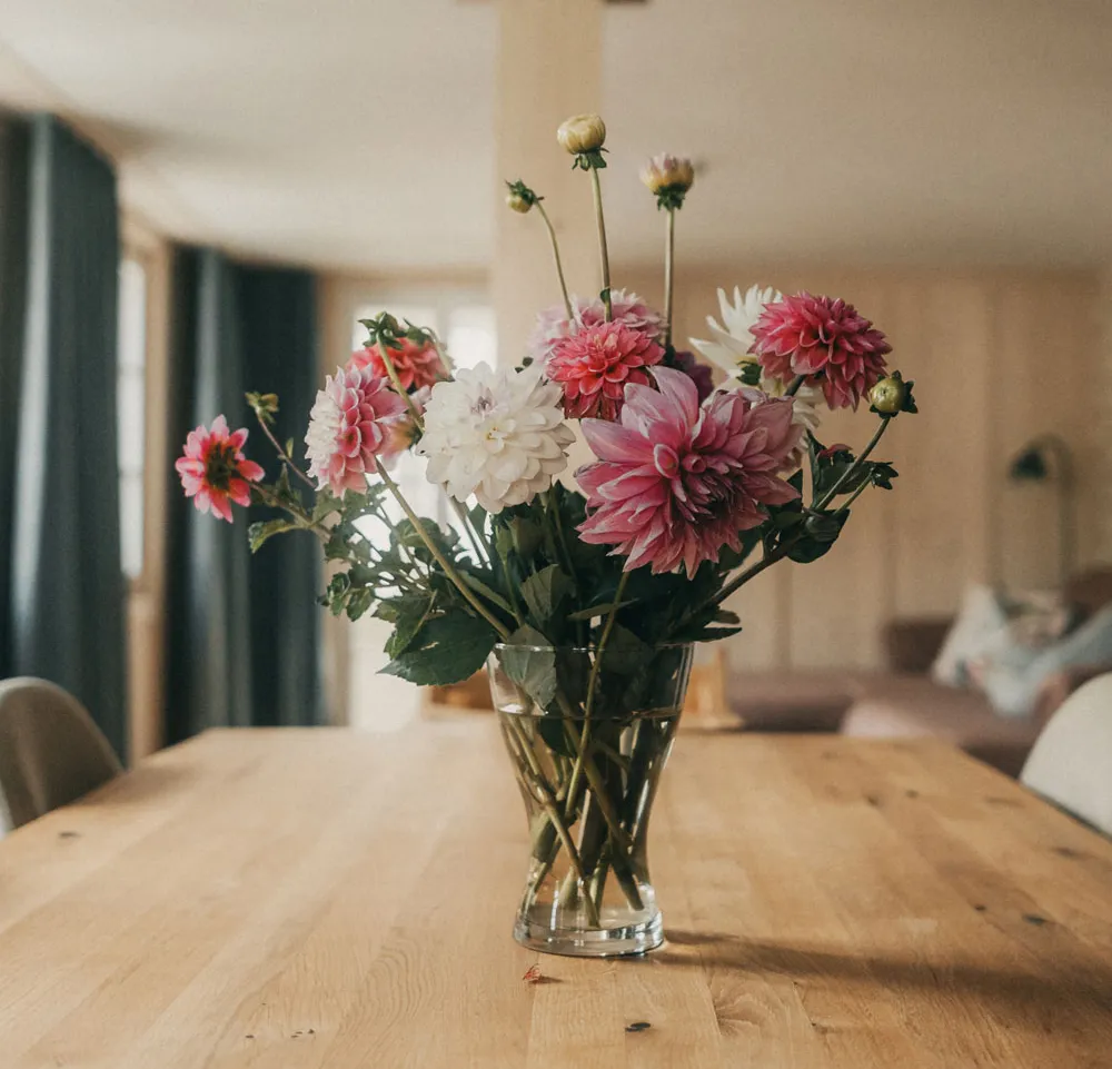 Blumenstrauss auf Holztisch in Vase mit Wasser