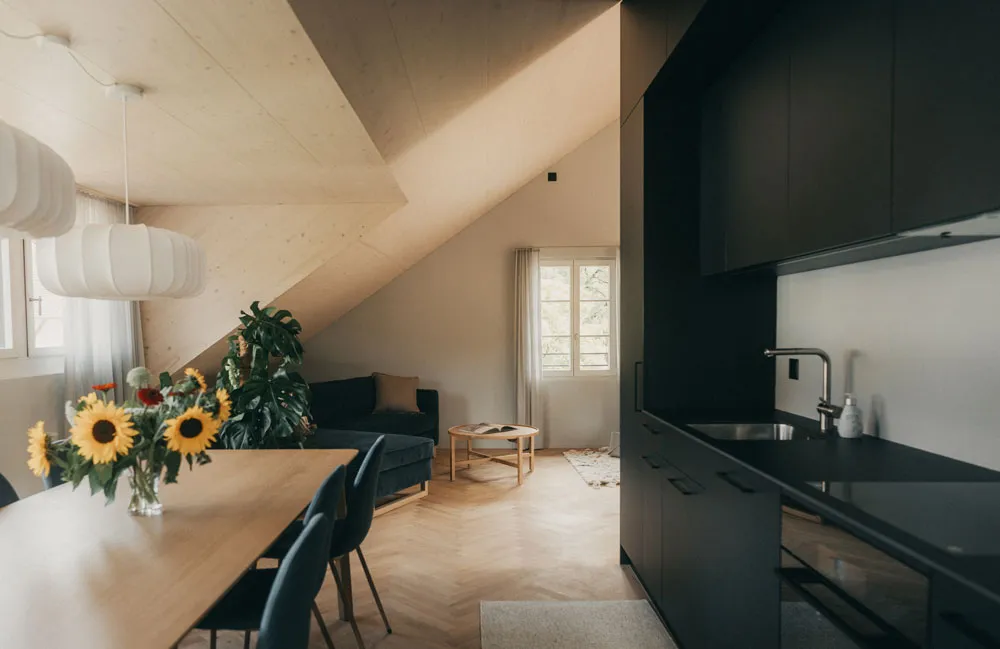 Küche mit Holztisch mit Sonnenblumen in der Dachsuite im Geburtshaus am Mülibach