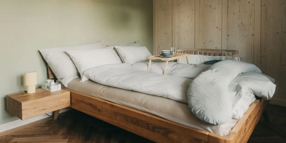 Bett mit Baby-Beistellbett und Frühstückstablett im Wochenbettzimmer