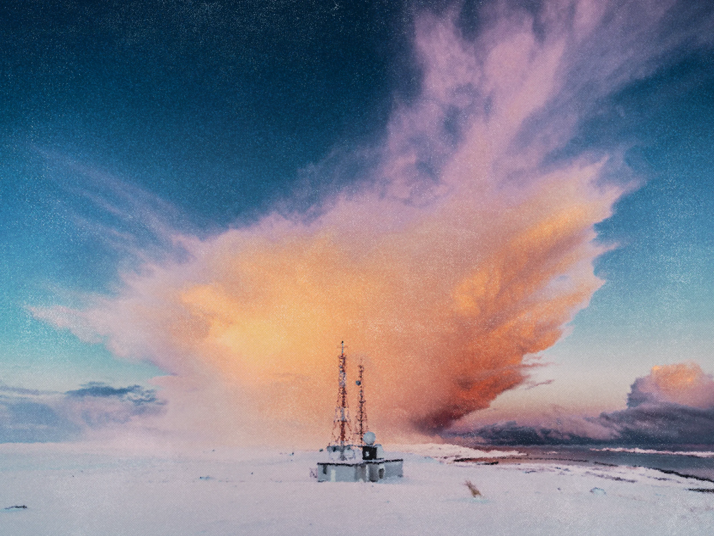 Snow-covered landscape with a small building and tall communication antennas under a dramatic sunset sky with colorful clouds.