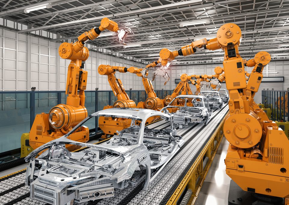 Orange robots welding car bodies on an assembly line