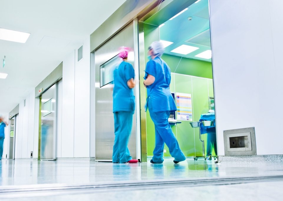 Hospital staff in scrubs in a bright clinic corridor