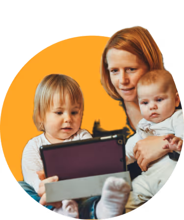 Woman with two young children looking at a tablet together against an orange background.