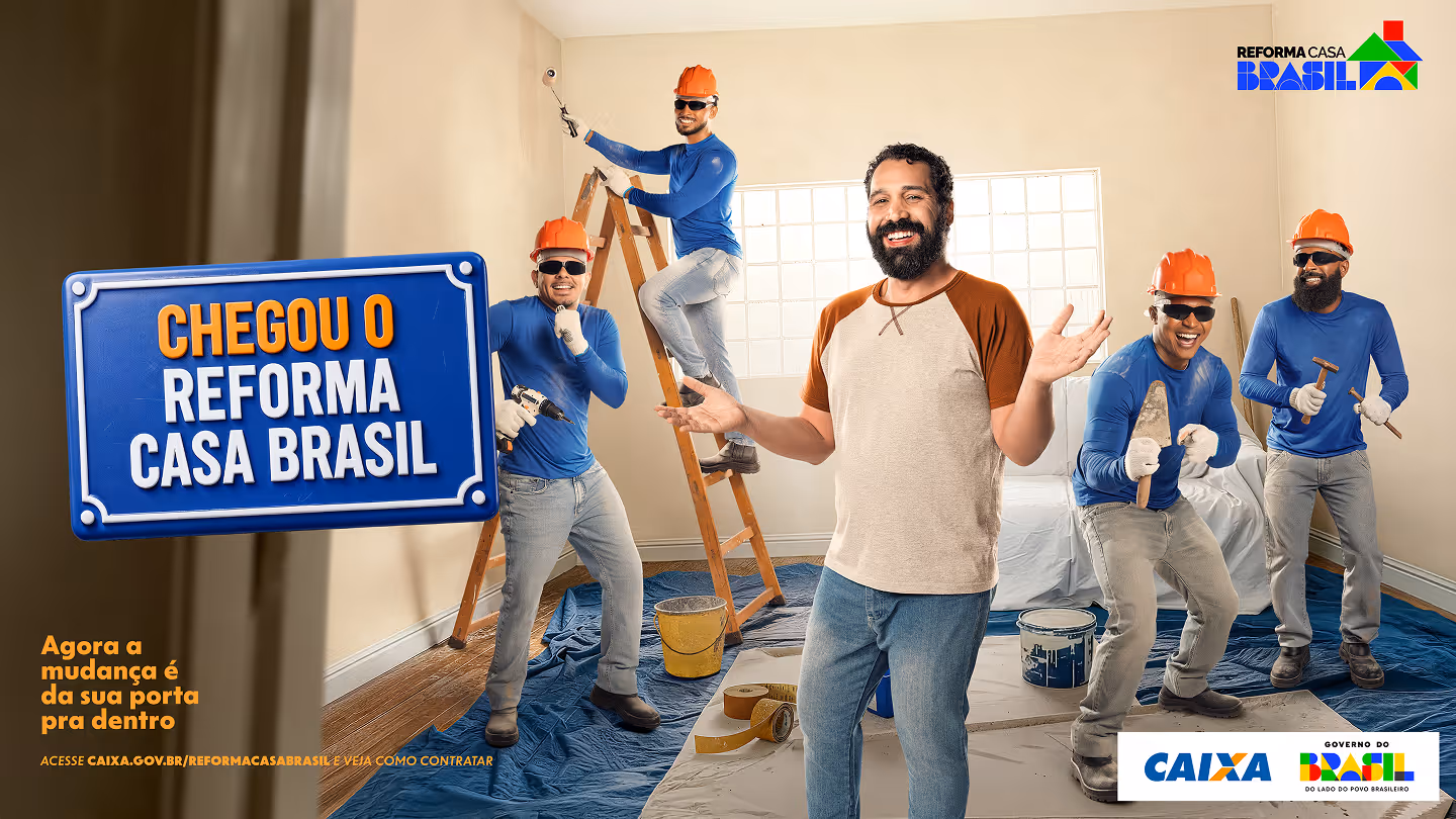 Five men in a room under renovation, four wearing orange hard hats and blue shirts working with painting and masonry tools, one man in casual clothes smiling with arms open. Text reads 'Chegou o Reforma Casa Brasil' and 'Agora a mudança é da sua porta pra dentro.'
