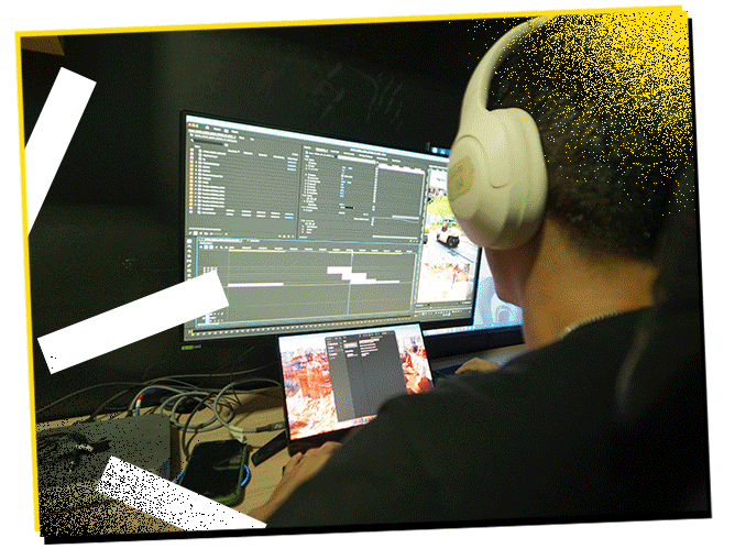 Person wearing white headphones editing video on a dual-monitor computer setup.