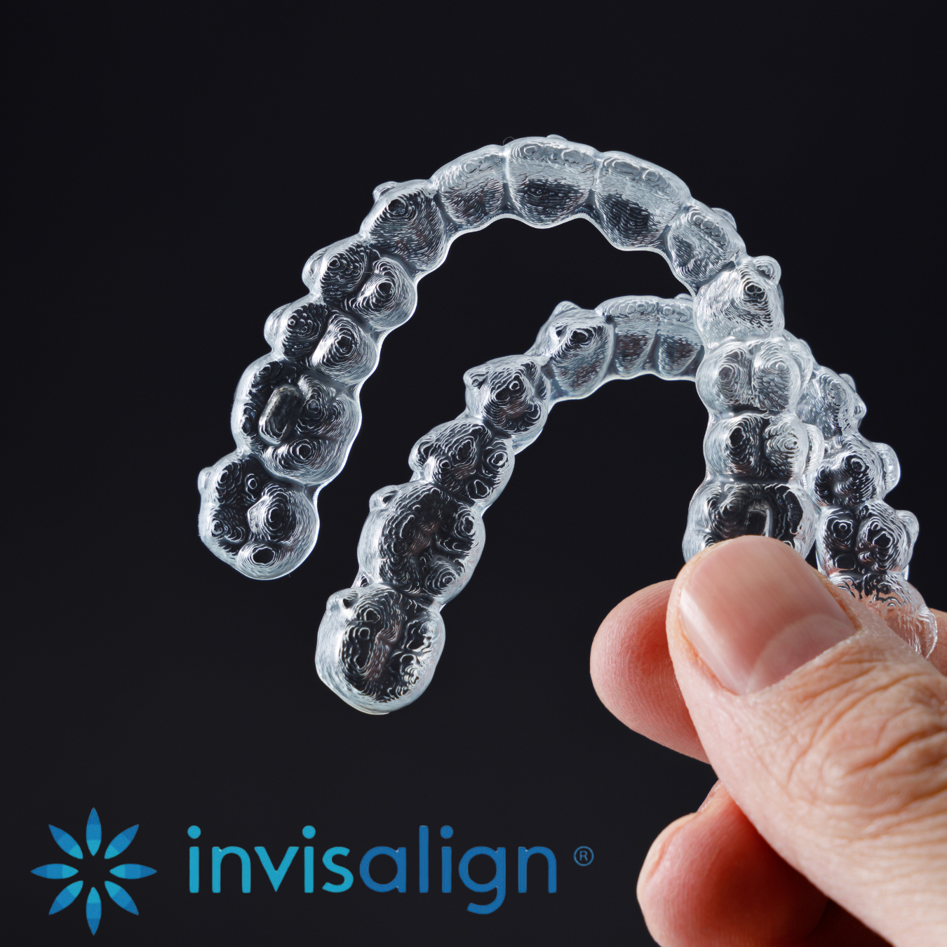Patient holding clear Invisalign aligners at MDRN MUSE Dental Aesthetics in Chattanooga, TN
