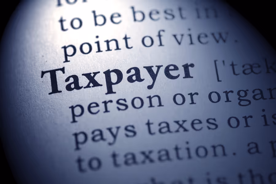 Close-up of dictionary definition for taxpayer with soft lighting