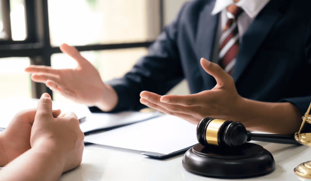 Lawyer discussing legal case with client, gavel on desk
