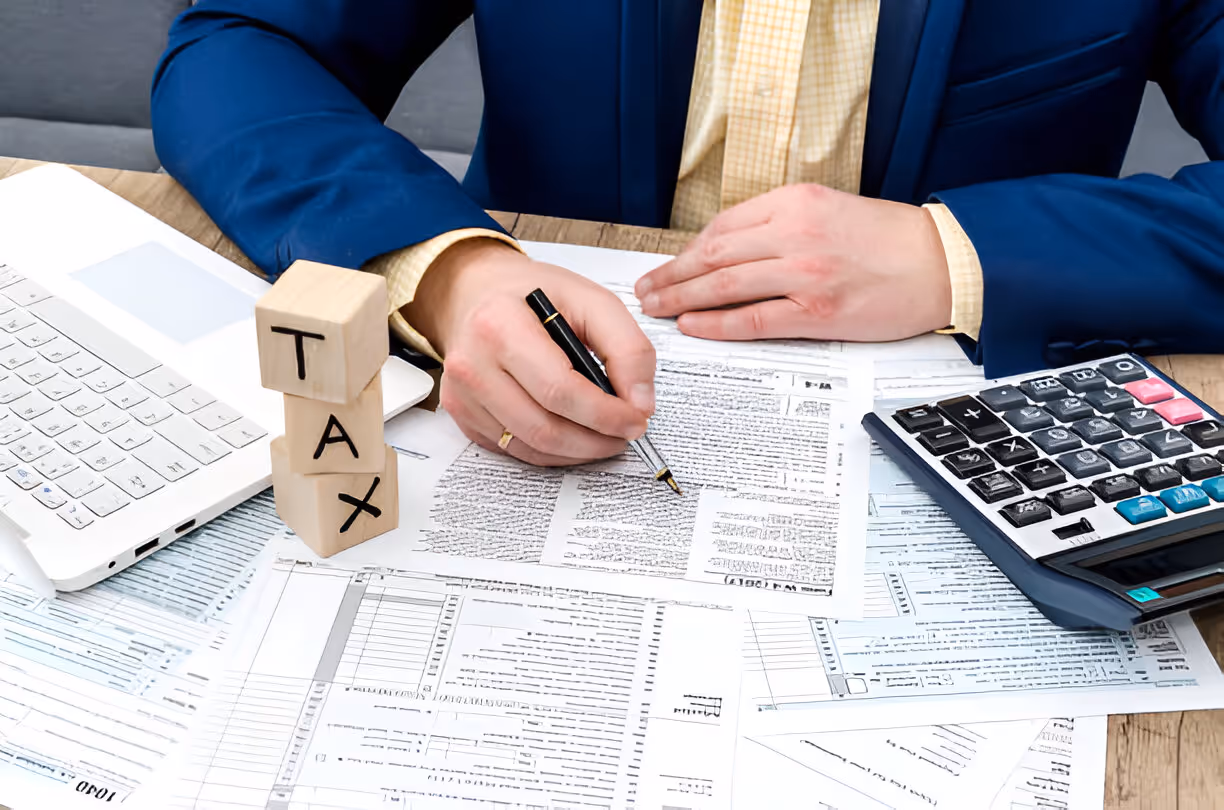 Wooden figures, coins, money bags, house, and car symbolizing financial planning