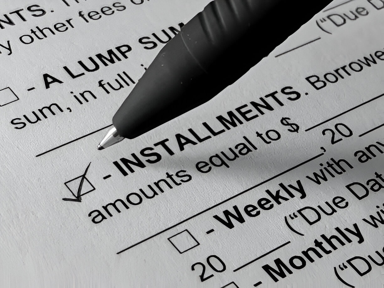 Black pen marking installment payment form with checkboxes