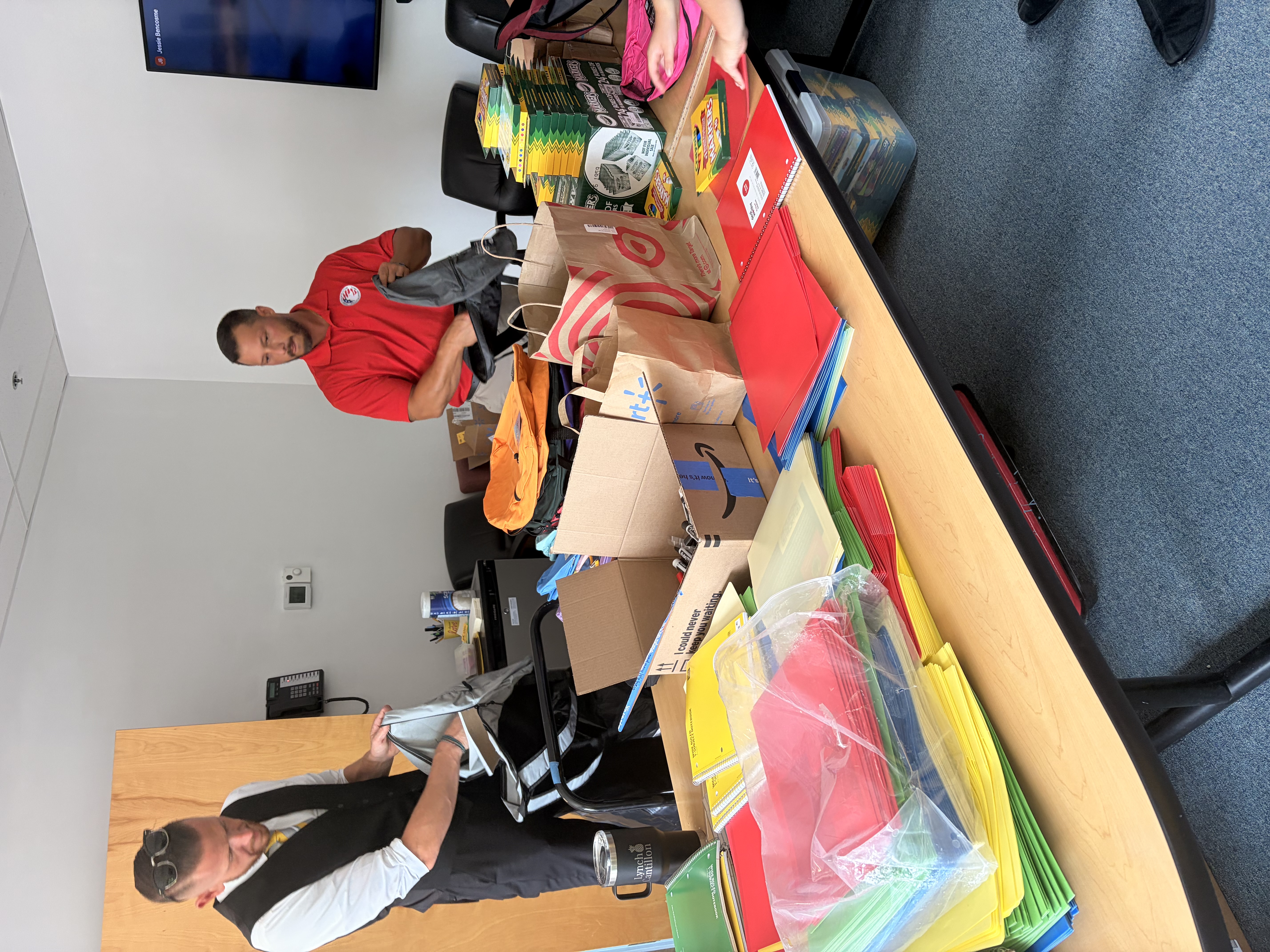 Volunteers packing backpacks with school supplies