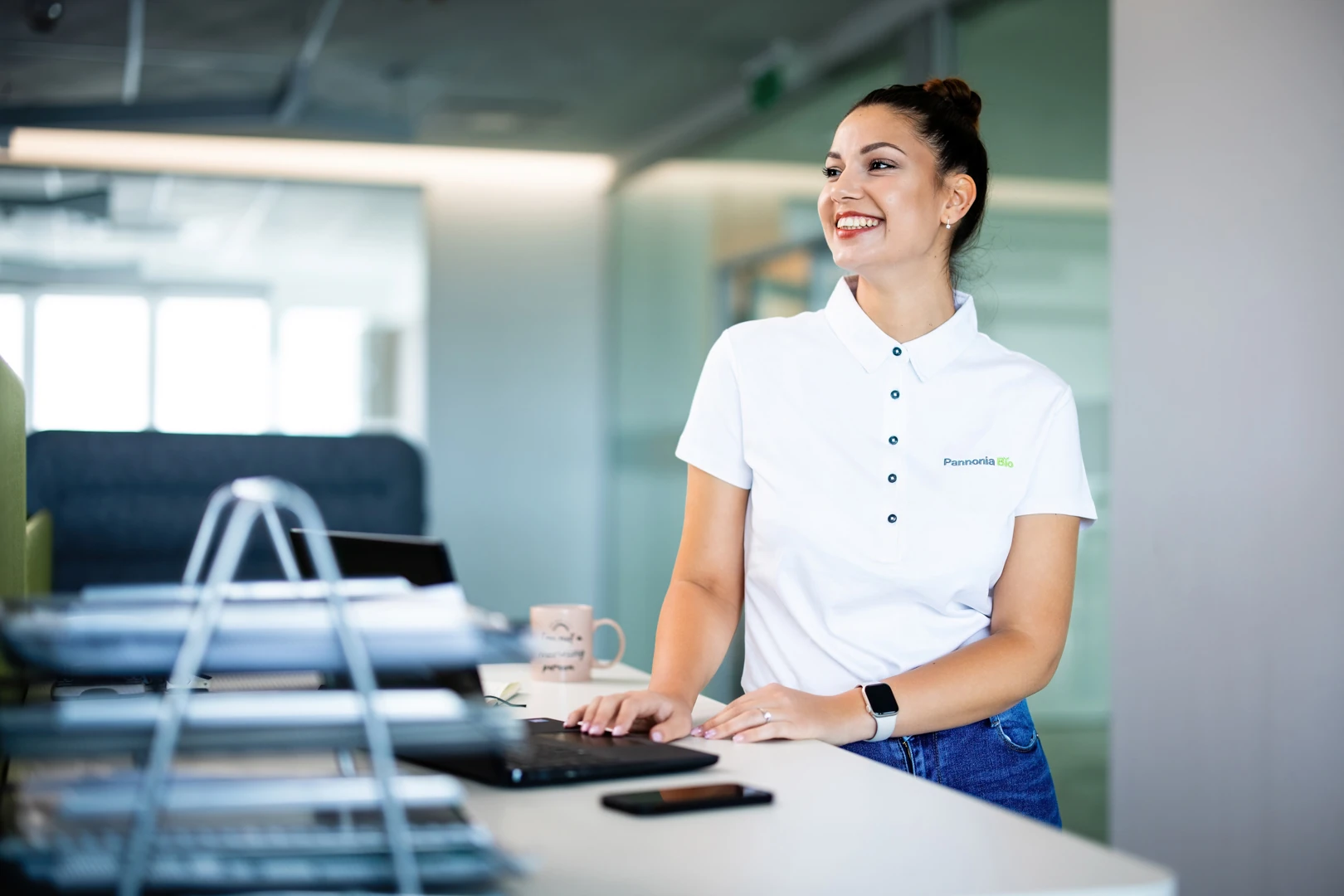 Smiling Pannonia Bio employee working at a standing desk