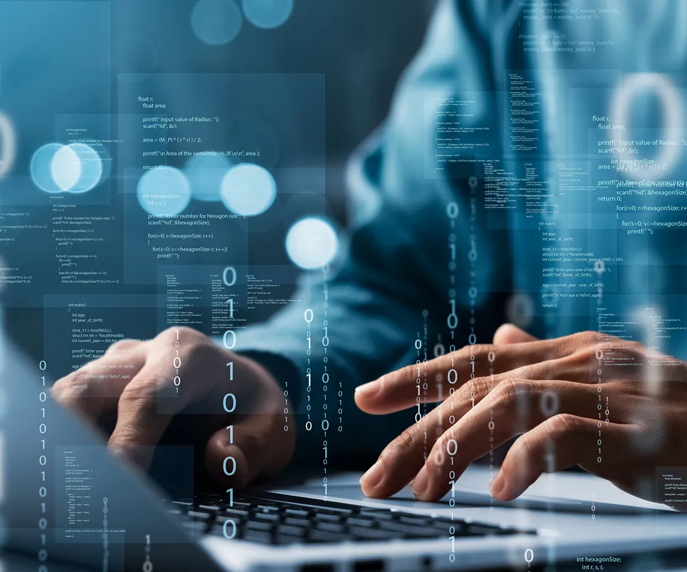 Close-up of hands typing on a laptop keyboard with overlaid transparent digital code and programming syntax floating in the air, symbolizing software development and coding.