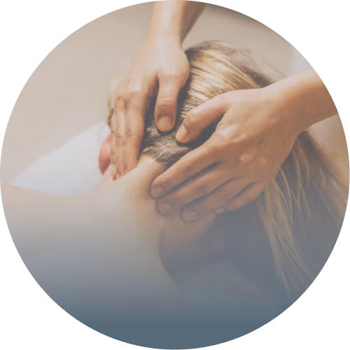 Hands massaging the back of a person's neck and head with blonde hair.