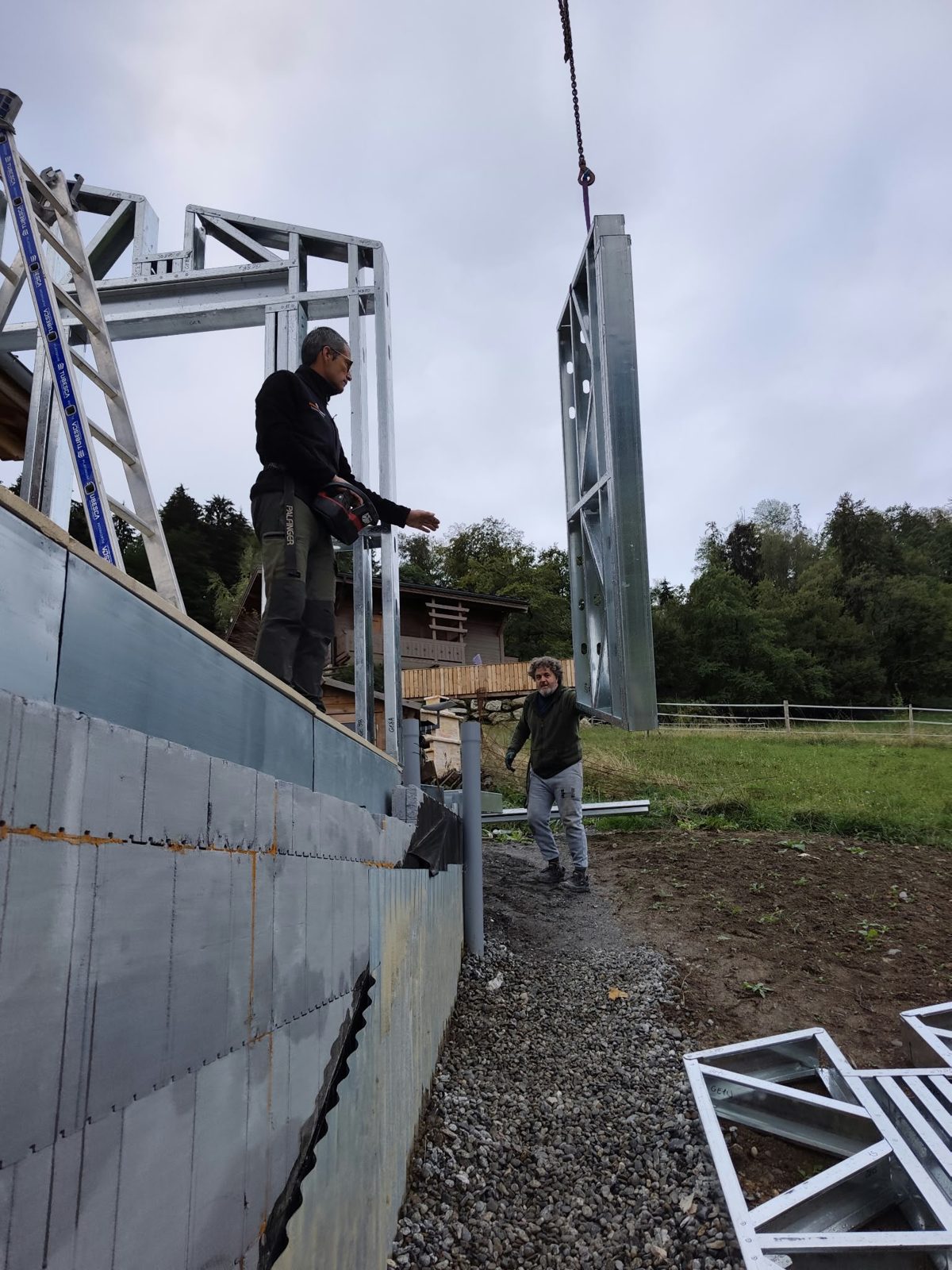 Levage d'un mur préfabriqué en ossature métallique légère sur le chantier de Combloux