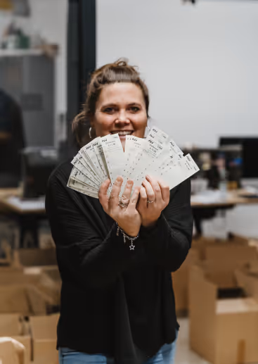 Eine Frau mit vielen Bestellungszetteln für Spendenpakete.