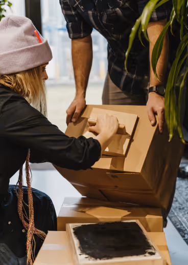 Bedrucken eines Spendenkartons mit dem Support Your Neighbour Logo.