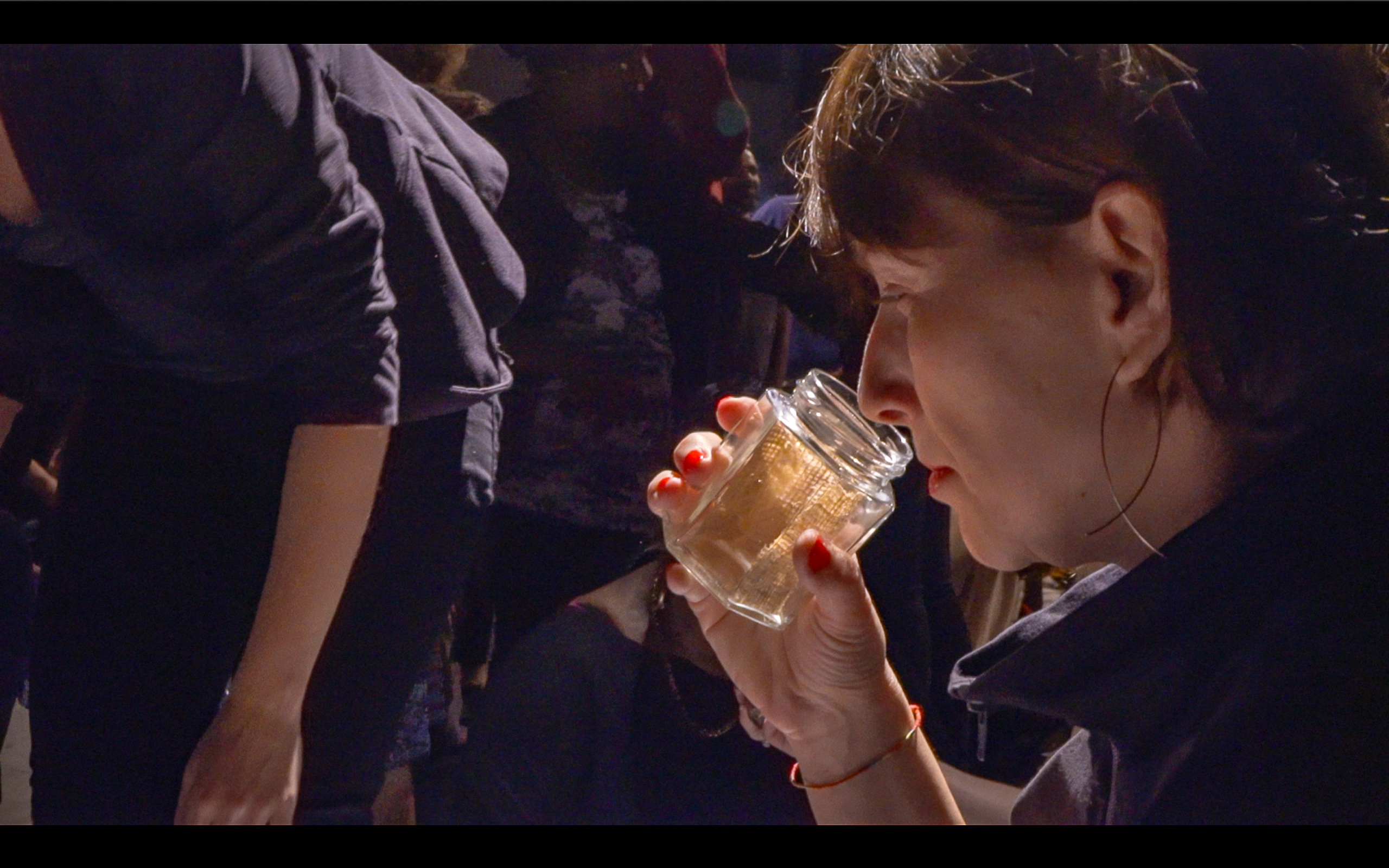 An audience member smelling the inside of a glass jar