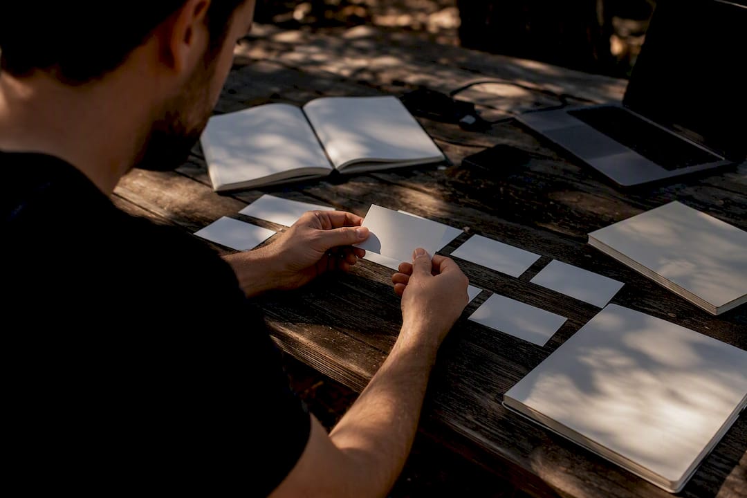 Hands arranging analytics funnel cards on table