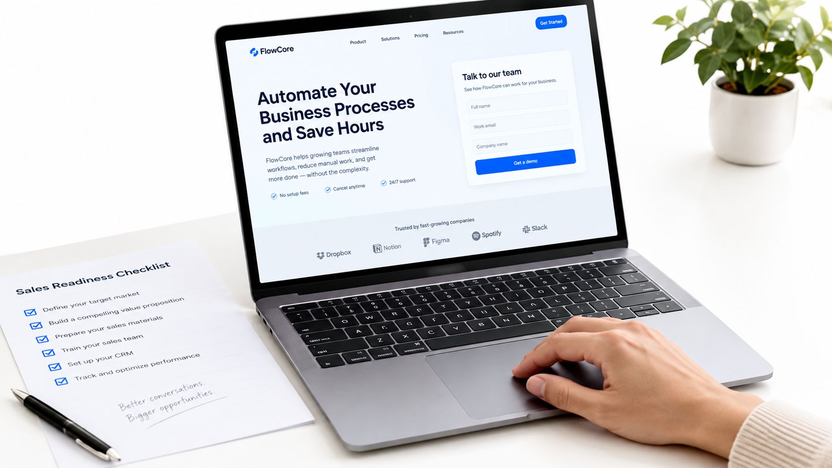 A professional laptop showing a FlowCore automation software webpage with a sales readiness checklist nearby.