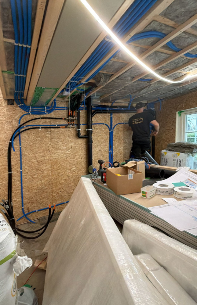 Haustechnik-Installation mit Elektro- und Wasserleitungen im Technikraum eines modernen Holzhauses / Schwedenhaus