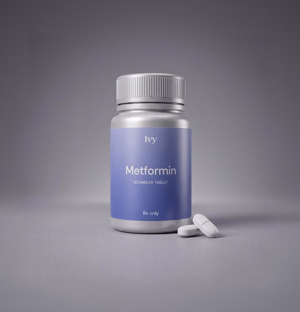 Silver bottle labeled Metformin 500MG ER tablet with two white pills on gray surface.