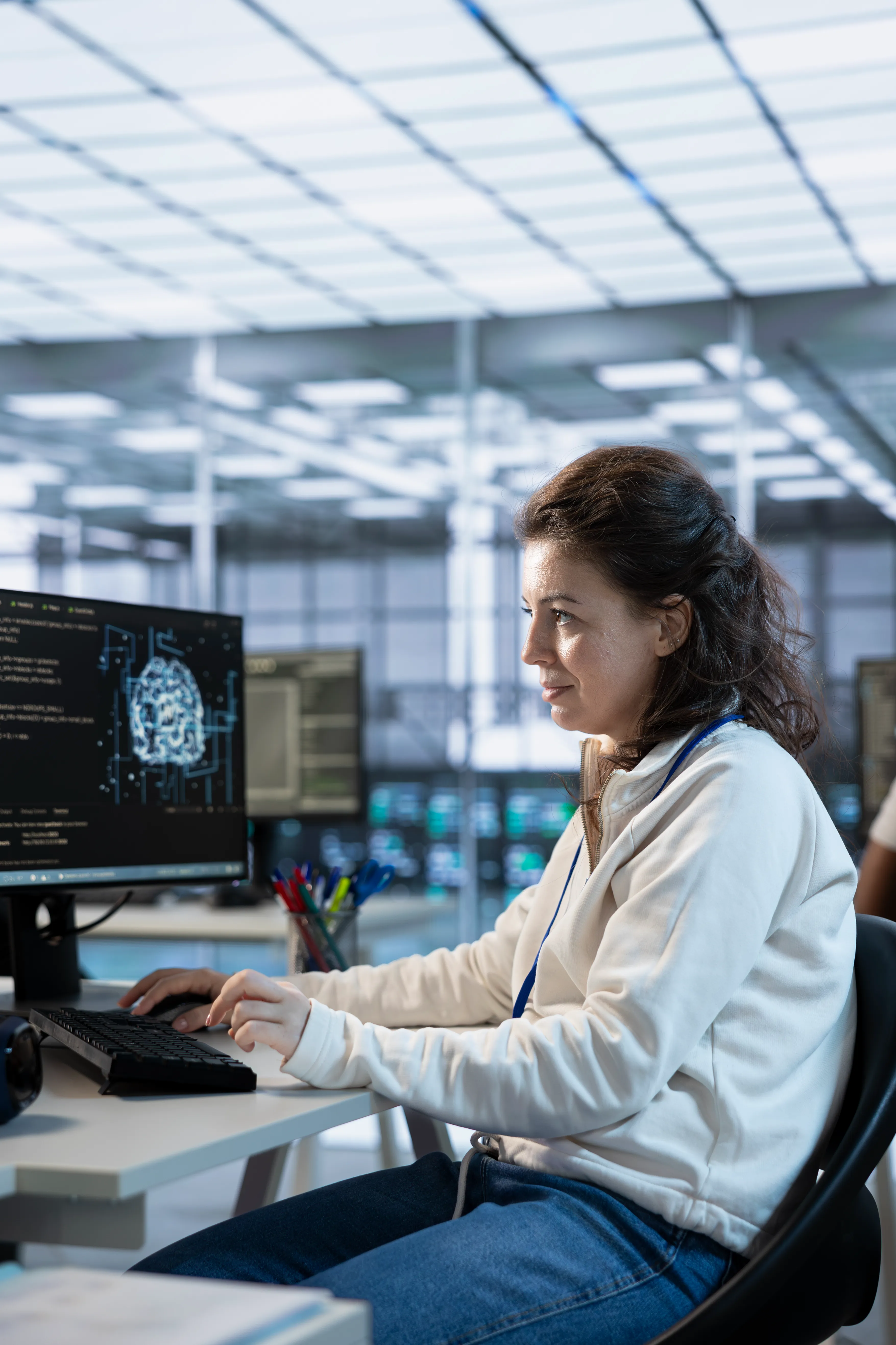 Delante de una computadora hay una mujer que está utilizando IA Software para su empresa
