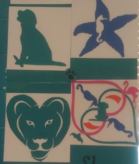 Artistic designs featuring a green silhouette of a cat with a mouse, a blue starfish with a seahorse inside, a green lion head, and a butterfly shape with various small animal silhouettes inside.
