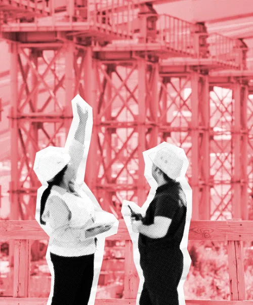 Two people with hard hats overlooking a construction site.