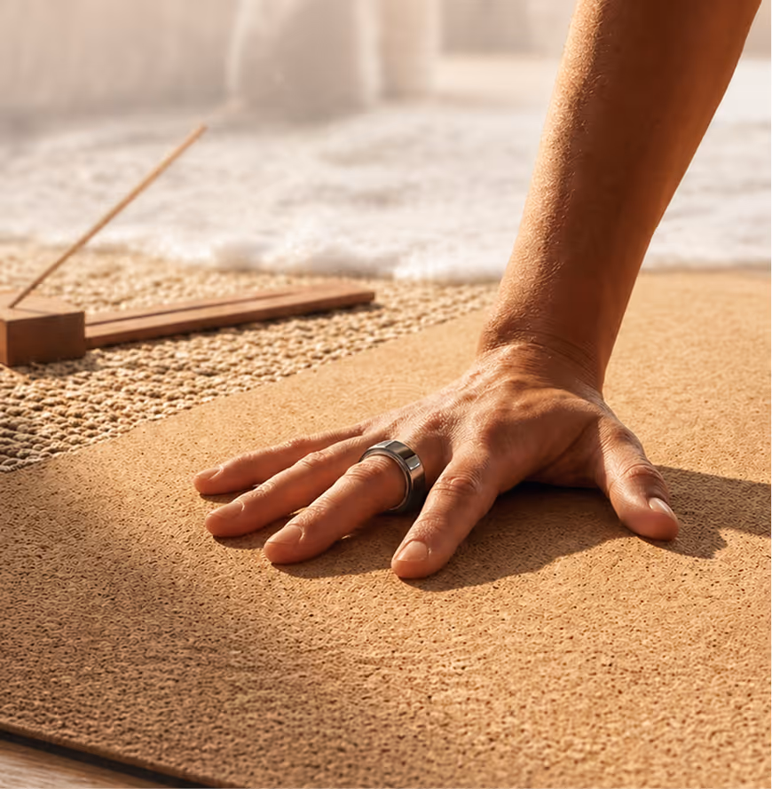 Close-up of a hand on a textured yoga mat with an incense holder in the background.