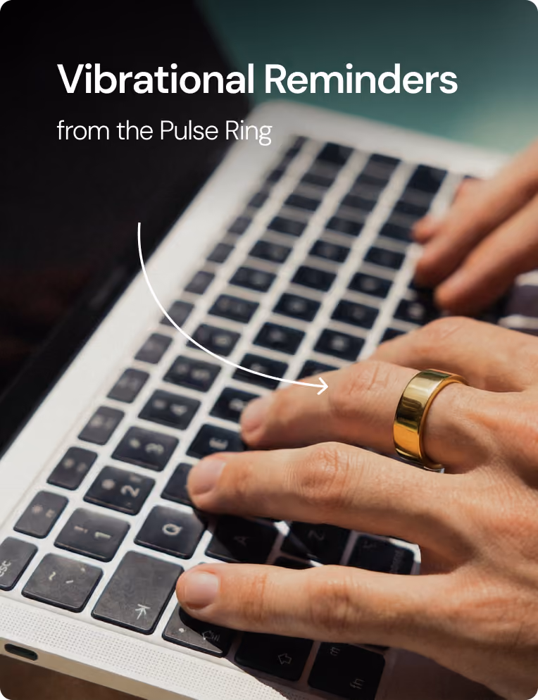 Hand wearing a gold Pulse Ring typing on a laptop keyboard with text Vibrational Reminders.