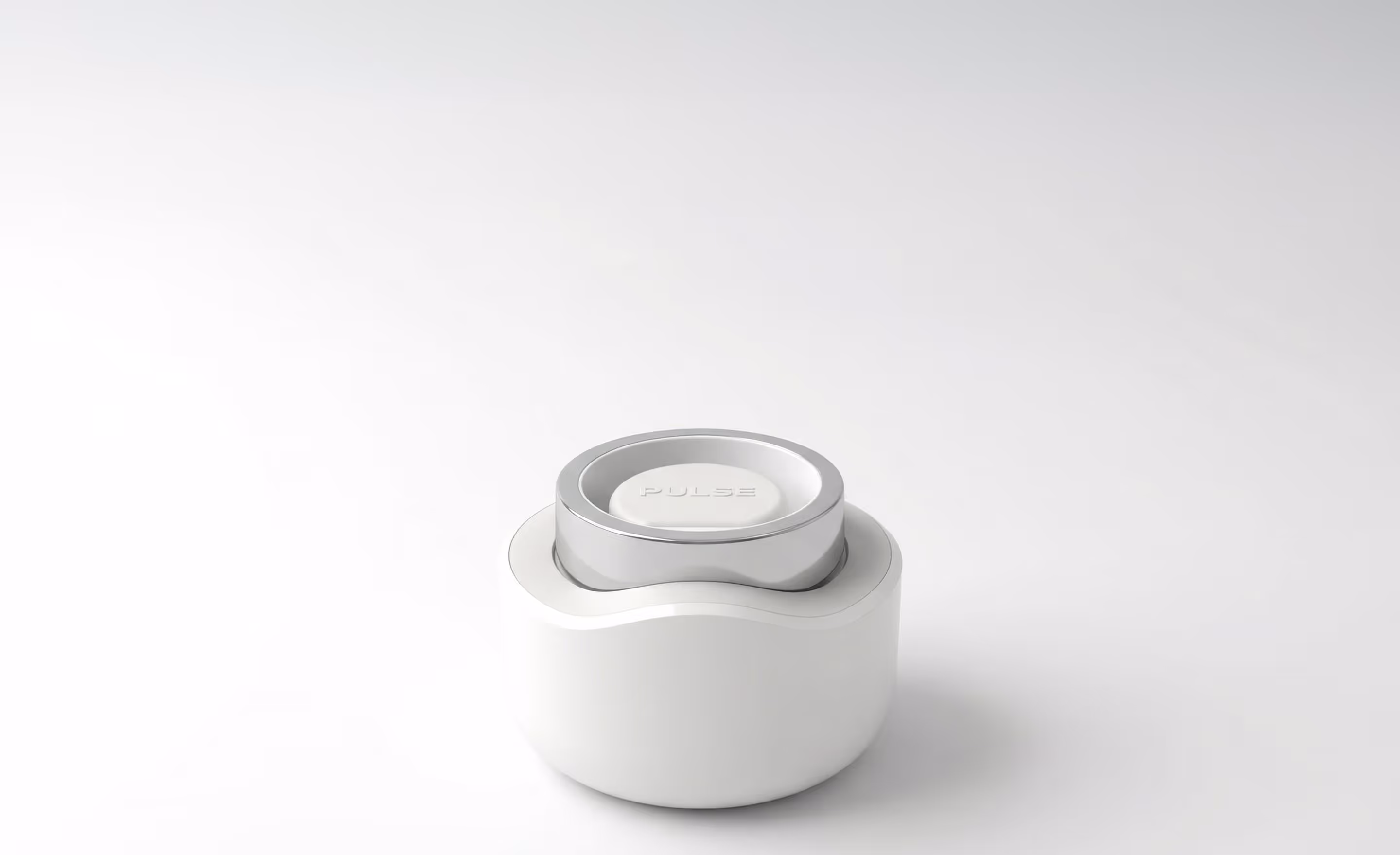 Small white and silver device labeled PULSE on a smooth white surface.