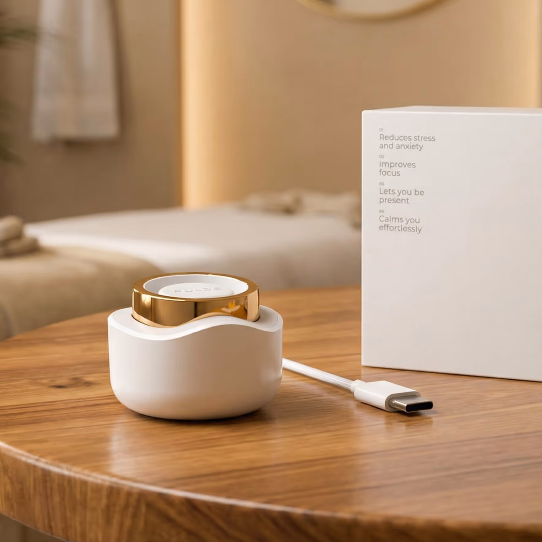 White and gold circular device on charging dock with USB-C cable on a wooden table.