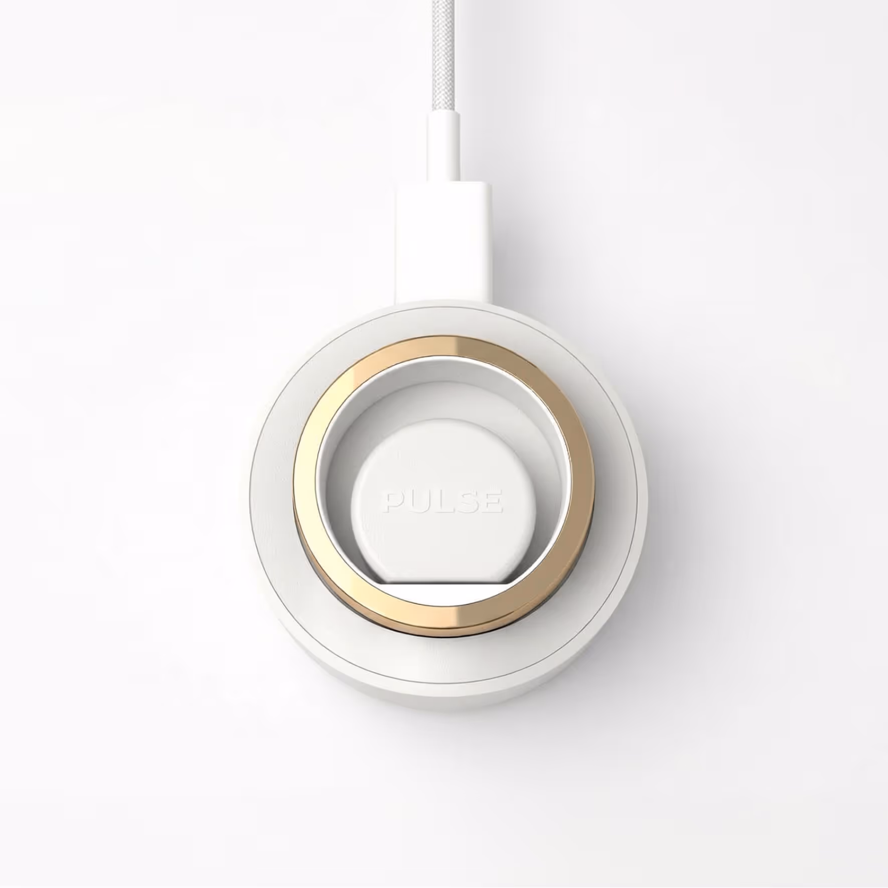 White circular device with a gold ring and 'PULSE' engraving connected to a white cable.