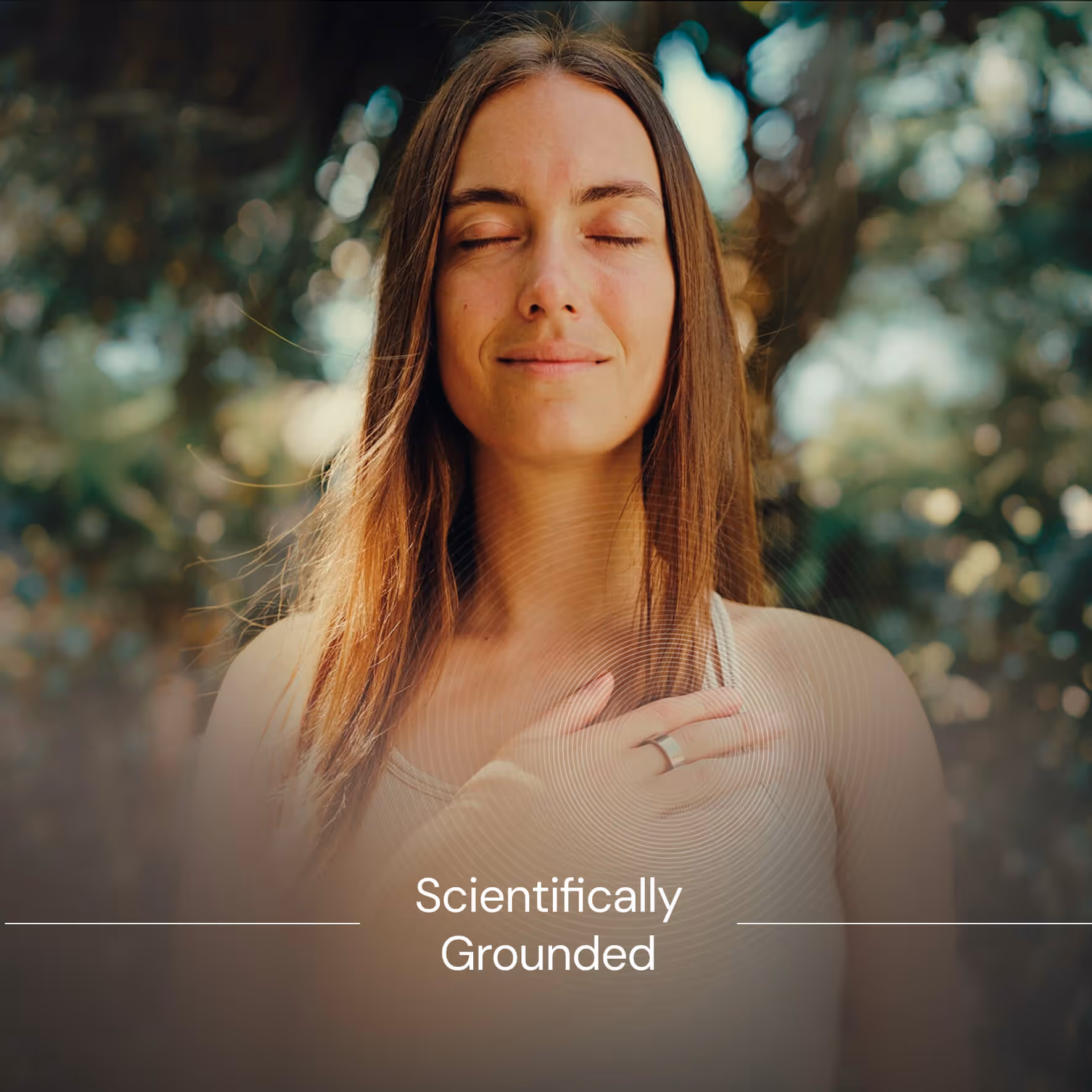 Woman with long hair and closed eyes touching her chest outdoors with sunlight and blurred background.