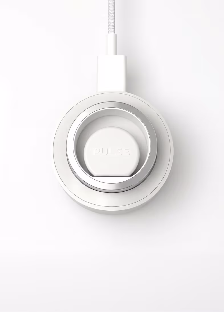 White circular wireless charger with silver ring and PULSE text on a white background.