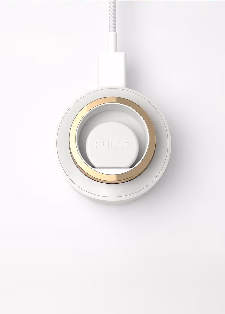 White circular Pulse wireless charger with gold ring on a white surface.