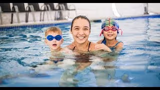 photo of an instructor and two children swimming in a pool