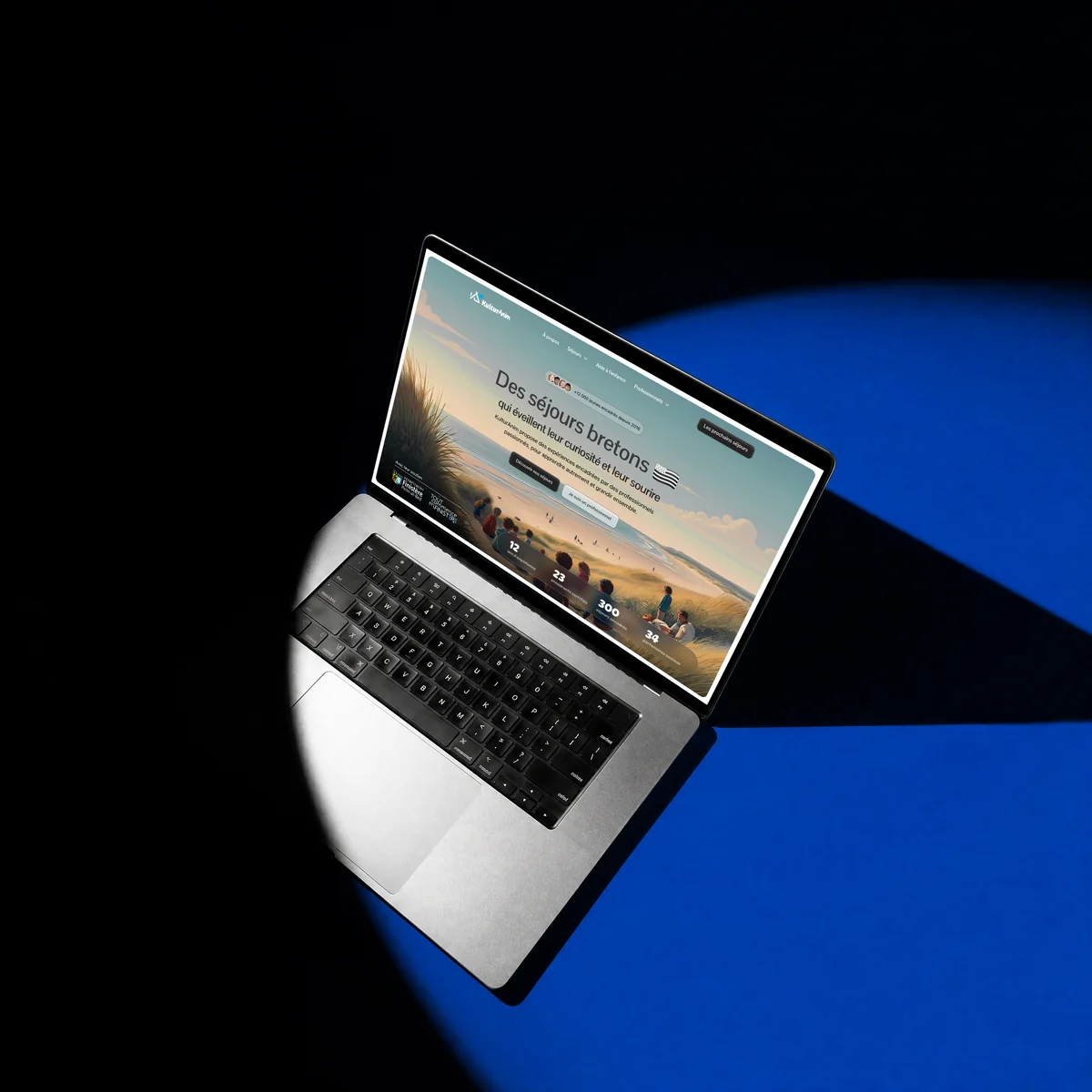 Site web KulturAnim réalisé par l'agence Apollo à Brest : la page d'accueil sur un MacBook sous un faisceau de lumière bleue