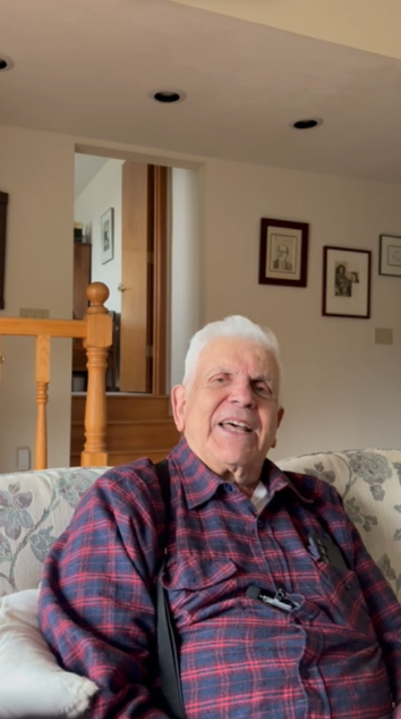 Older man sitting on couch looking at camera