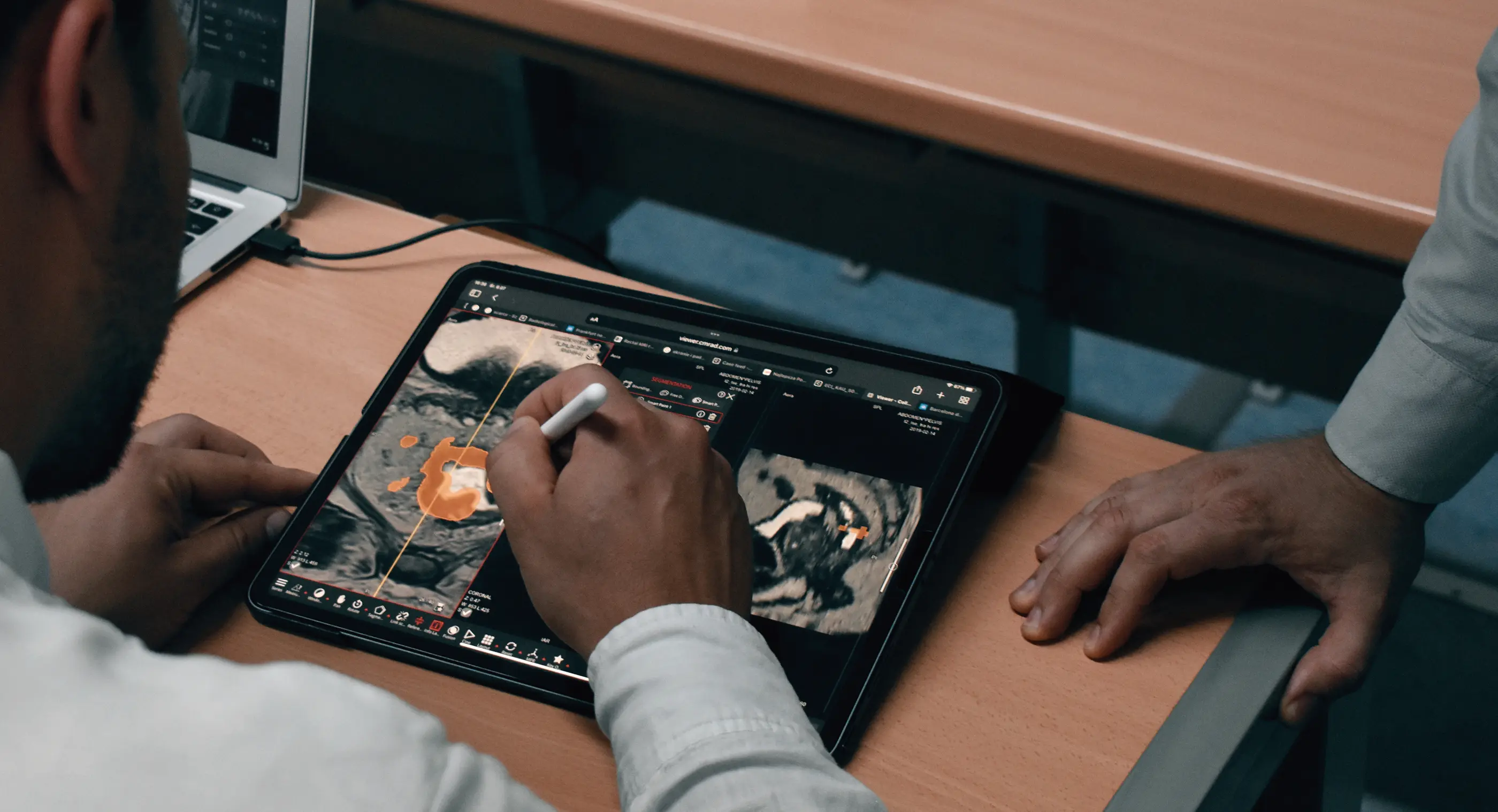 Hands annotating a document on a tablet at a desk