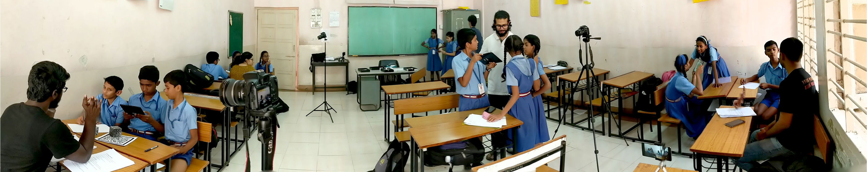 A full classroom of students during a research session, with a camera on a tripod recording