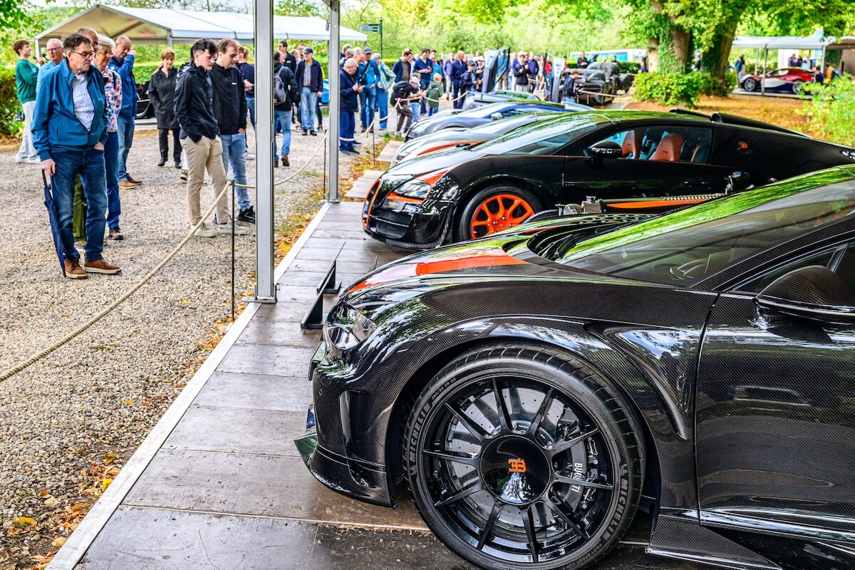 Bezoekers lopen langs moderne supercars op het landgoed