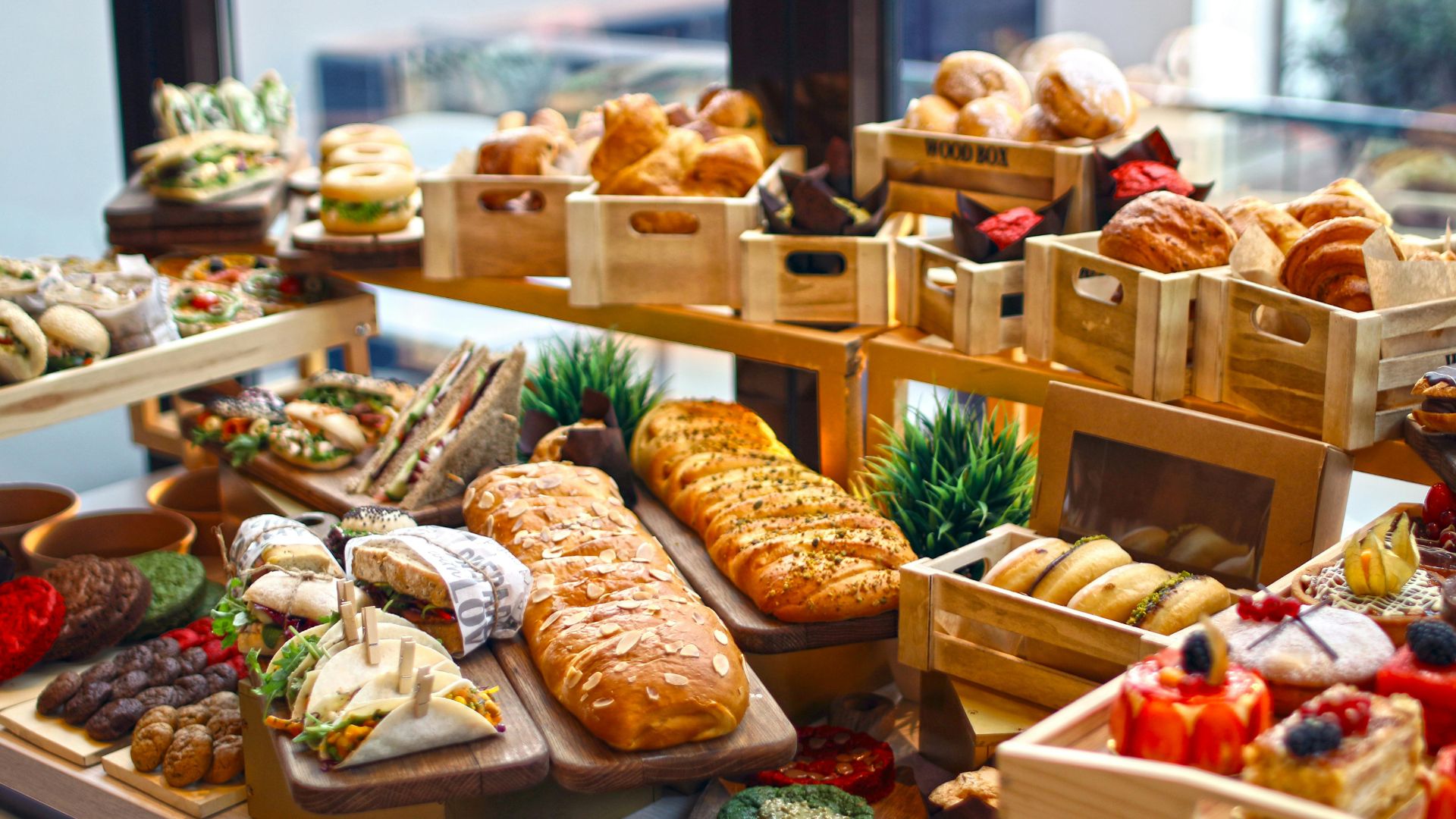 Variety of artisan breads, wraps, and sweet treats at a catered buffet display.