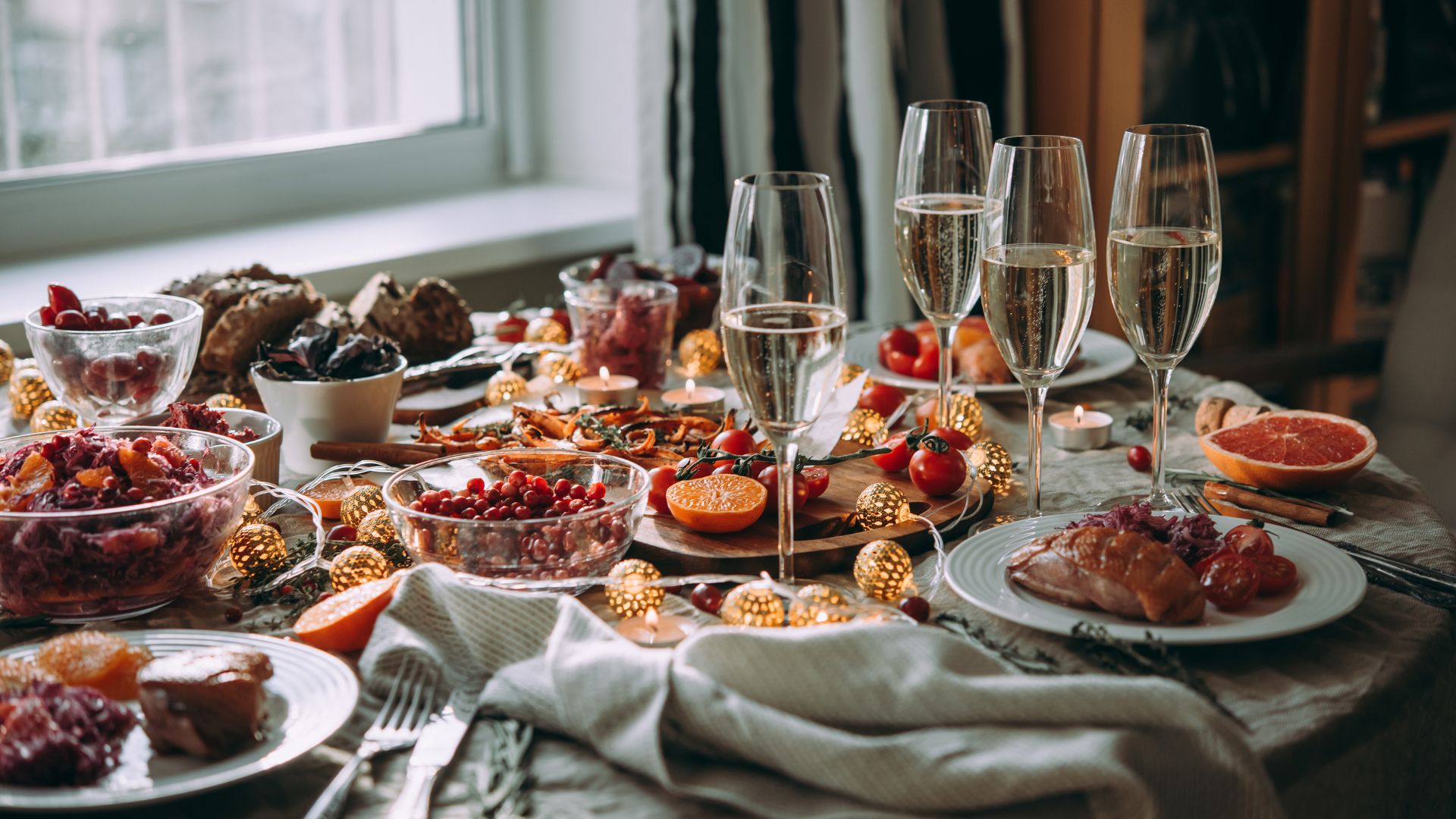 Festive office Christmas catering table with champagne glasses, seasonal dishes, and decorative lights in London